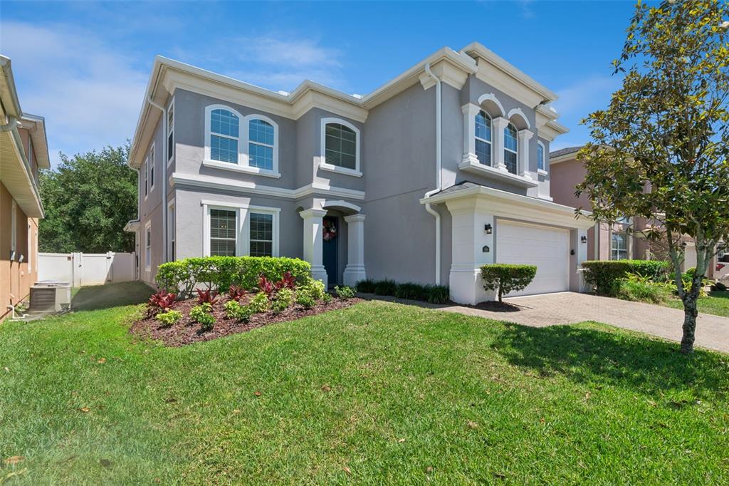 A two-story gray house with white trim, a front lawn, and a paved driveway — 509 SPRING RIVER DRIVE, ORLANDO, FL