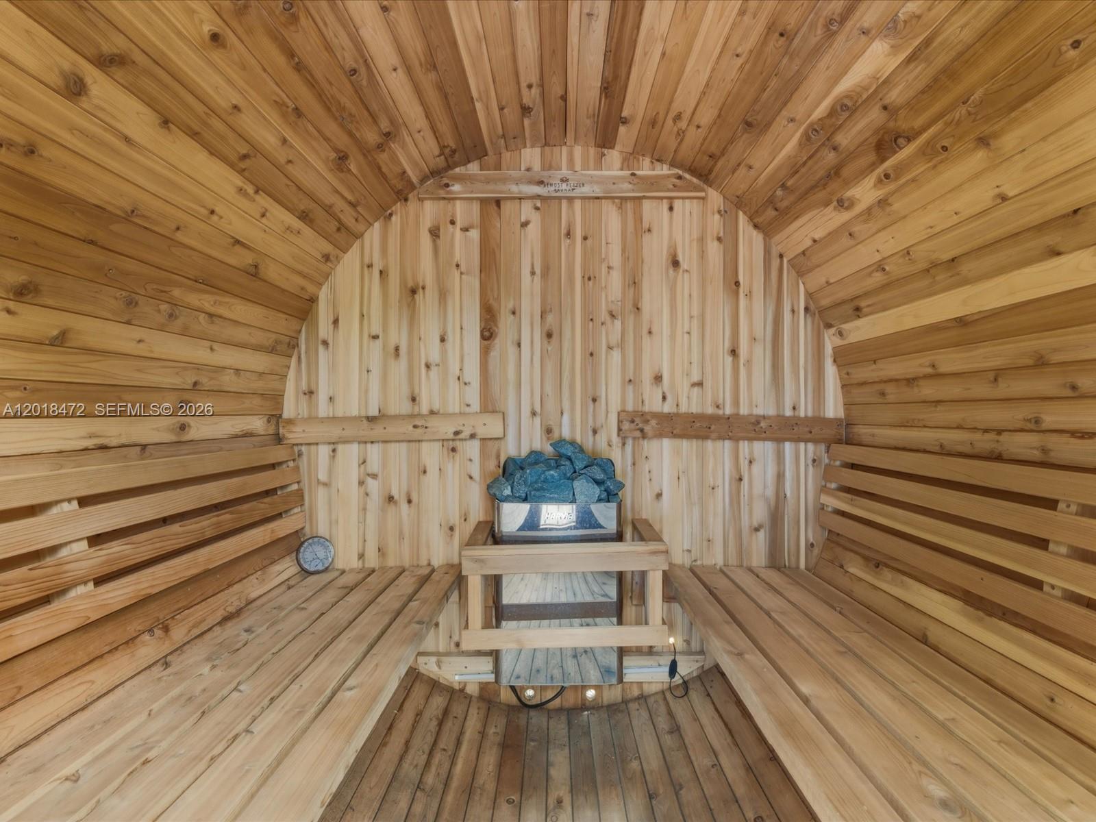 A barrel sauna features cedar wood paneling, two benches, and a central electric heater — 357 NE 117th St, Miami FL 33161, MIAMI, FL