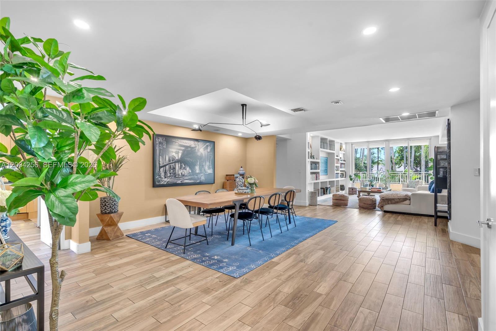 A dining area with a wooden table and blue rug opens into a living room — 791 Crandon Blvd # 302, Key Biscayne FL 33149, KEY BISCAYNE, FL