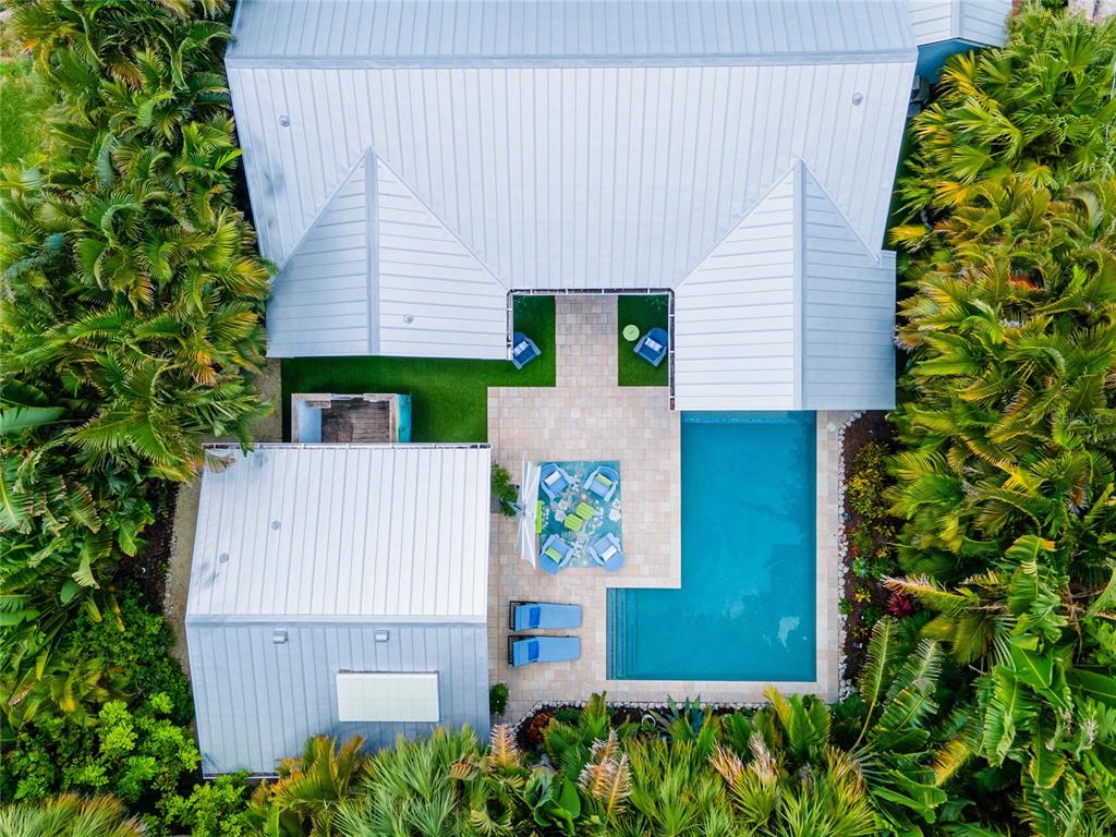 An aerial view shows a house with a metal roof, swimming pool, and patio area — 242 GLADIOLUS STREET, ANNA MARIA, FL