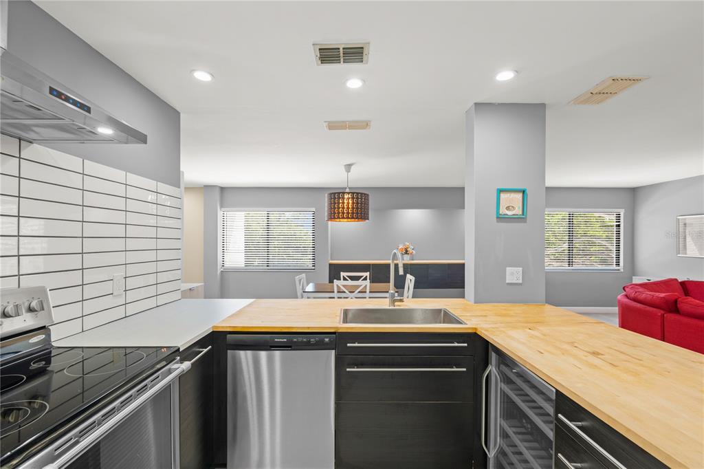 A kitchen with dark cabinets, a wood countertop, and a stainless steel dishwasher and stove — 2746 ORCHID OAKS DRIVE UNIT 301, SARASOTA, FL