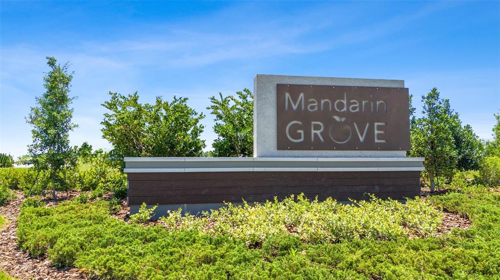 A sign for Mandarin Grove stands in a landscaped area with trees and bushes — 3723 109TH STREET EAST, PALMETTO, FL