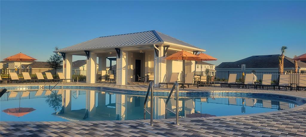 A swimming pool with a covered pavilion and lounge chairs under a clear blue sky — 3723 109TH STREET EAST, PALMETTO, FL