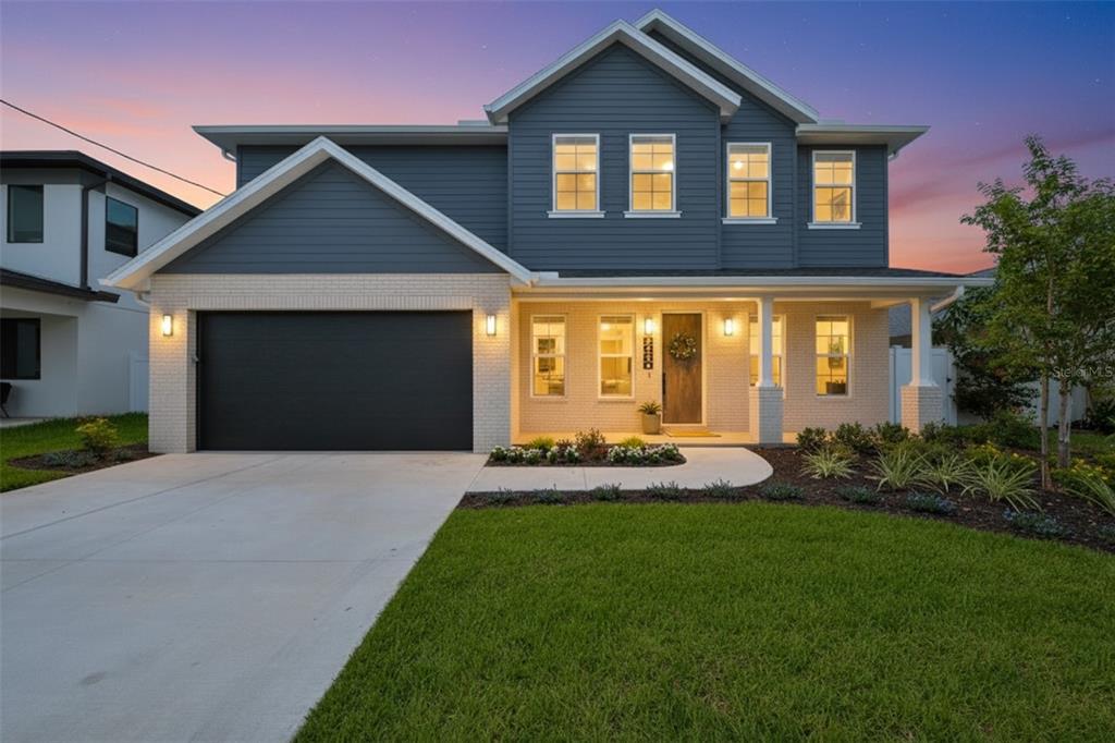 A two-story house with blue siding, a white brick facade, and a two-car garage — 3506 W ROGERS AVENUE, TAMPA, FL