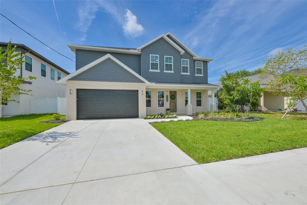 A two-story house with a gray exterior, brick facade, and a two-car garage — 3506 W ROGERS AVENUE, TAMPA, FL
