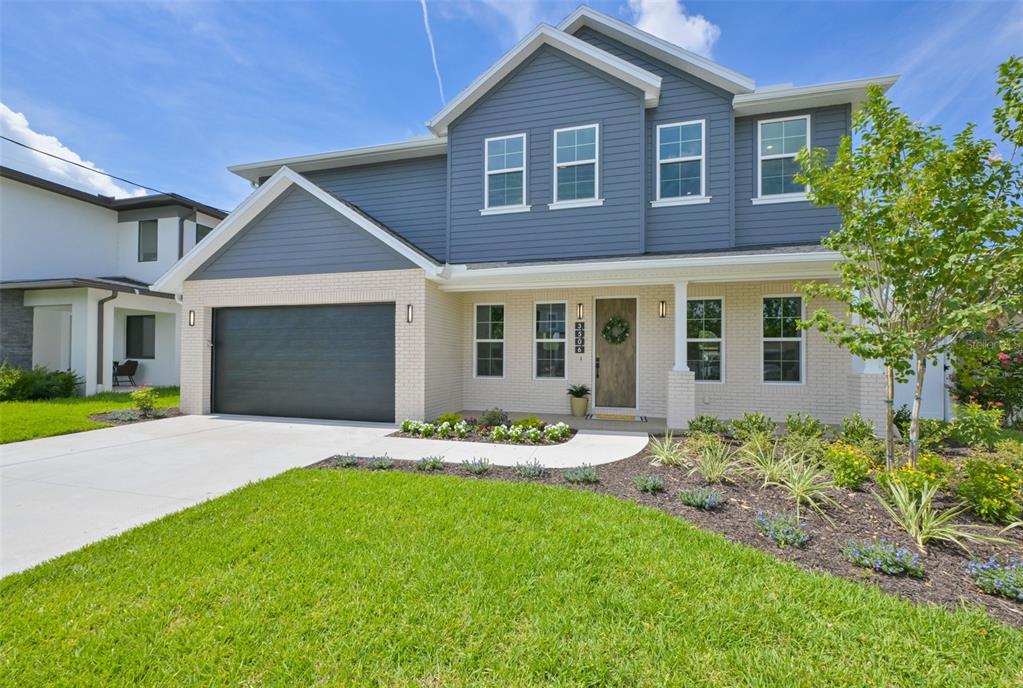 A two-story house with blue siding, a brick facade, and a two-car garage — 3506 W ROGERS AVENUE, TAMPA, FL