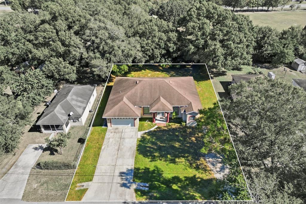 An aerial view shows a single-story house with a brown roof and a concrete driveway — 1218 37TH STREET NW, WINTER HAVEN, FL