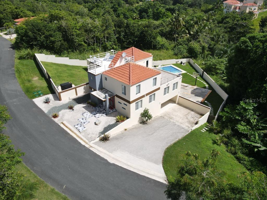 An aerial view of a two-story house with a tiled roof, pool, and paved driveway — 40 ROBLE VALLEY UNIT 40, HUMACAO, PR
