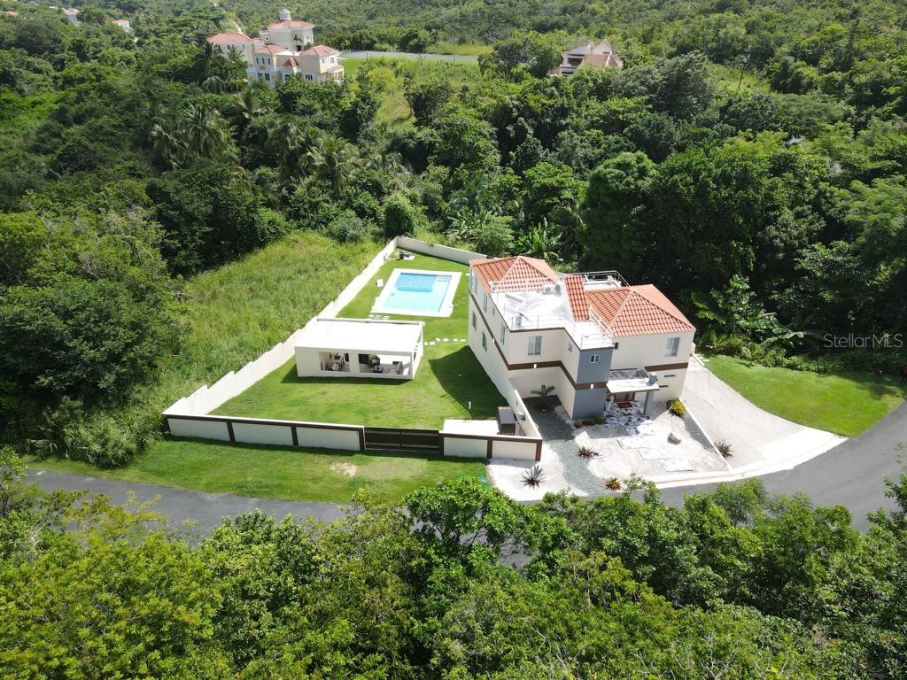An aerial view shows a two-story house with a pool, patio, and fenced yard — 40 ROBLE VALLEY UNIT 40, HUMACAO, PR