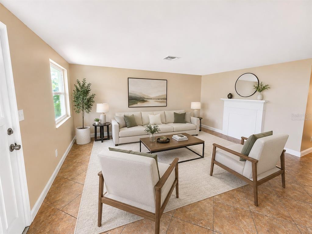 A living room features a beige sofa, two armchairs, a coffee table, and a fireplace — 7146 CARMEL AVENUE, NEW PORT RICHEY, FL