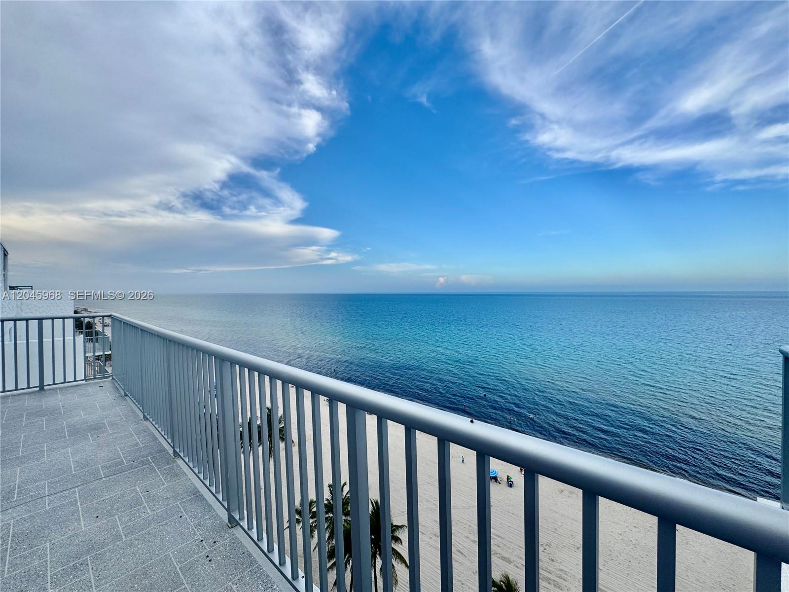 A balcony with a metal railing overlooks a sandy beach and the ocean — 400 N Surf Rd, Hollywood FL 33019, HOLLYWOOD, FL