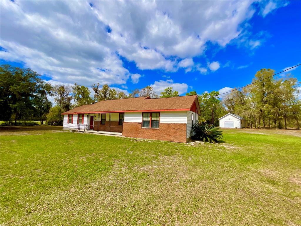 A single-story house with a brick and white siding exterior sits on a grassy lot — 2569 SE 50TH STREET, KEYSTONE HEIGHTS, FL