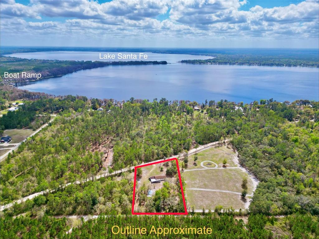 An aerial view shows a house on a wooded lot near Lake Santa Fe — 2569 SE 50TH STREET, KEYSTONE HEIGHTS, FL