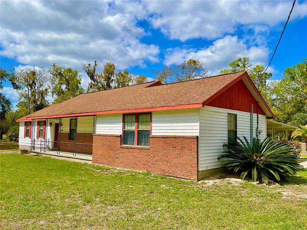 A single-story house with white siding, a brick base, and a covered front porch — 2569 SE 50TH STREET, KEYSTONE HEIGHTS, FL