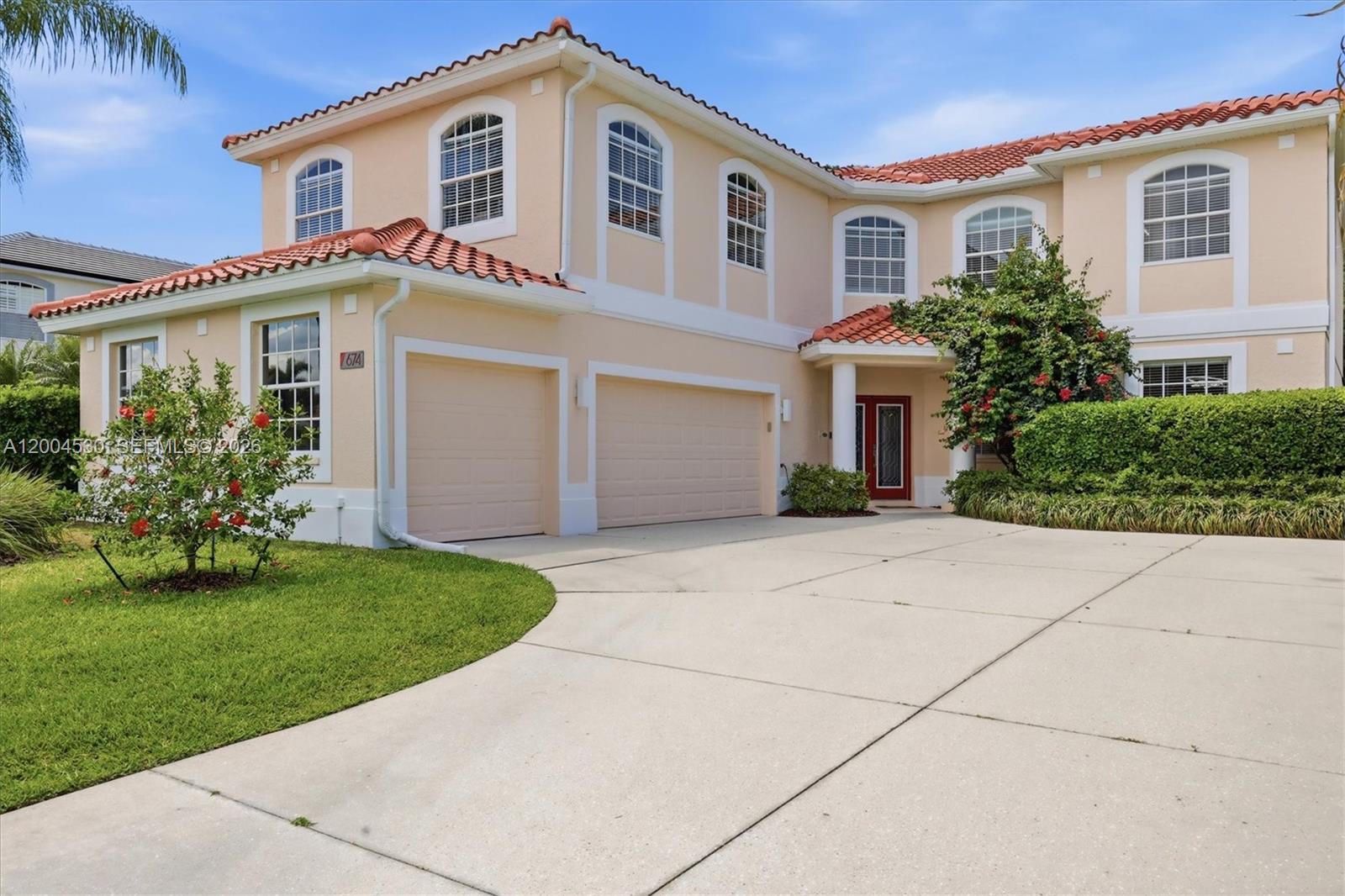 A two-story suburban house with a beige stucco exterior, red tile roof, and three-car garage — 674 Clear Creek Drive, Sarasota FL 34229, SARASOTA, FL