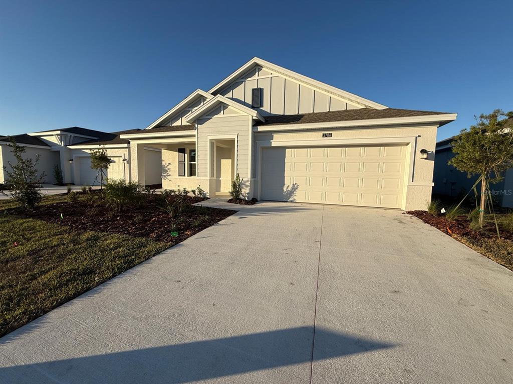 A light-colored single-story house with a two-car garage and a concrete driveway — 5786 GINGHAM DRIVE, KISSIMMEE, FL