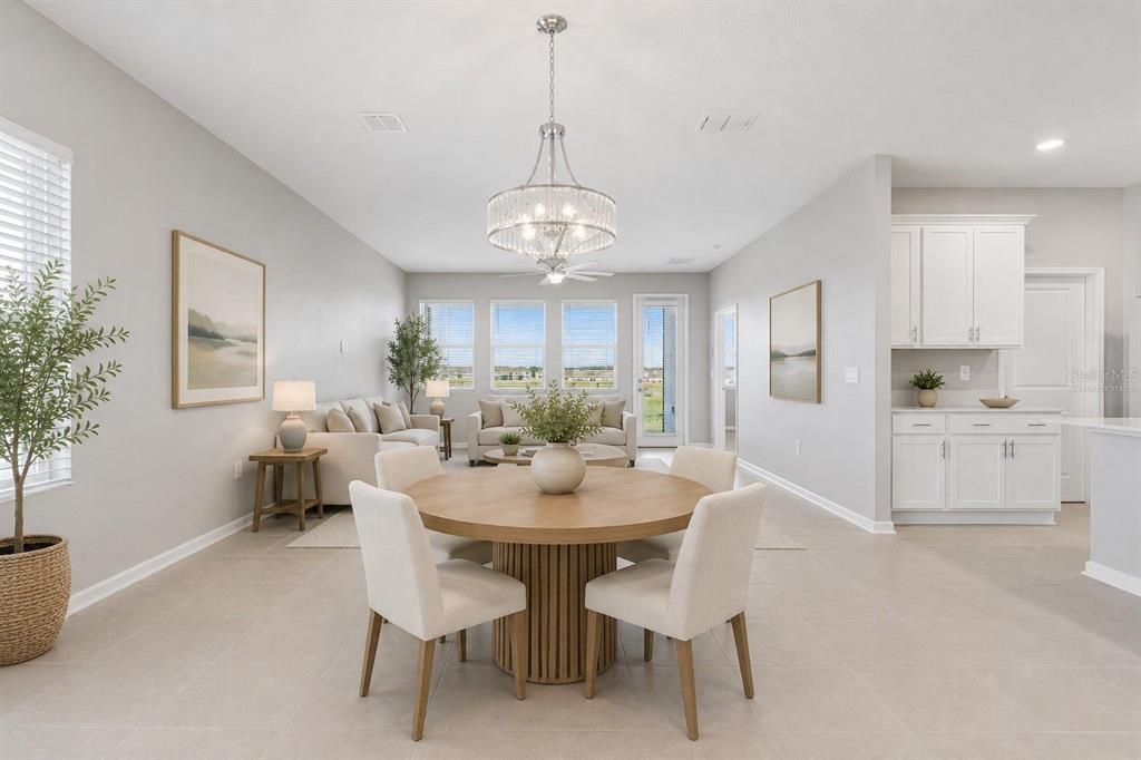 A bright, open-concept dining and living area with light tile floors and white cabinetry — 3012 NAMASTE DRIVE, CLERMONT, FL