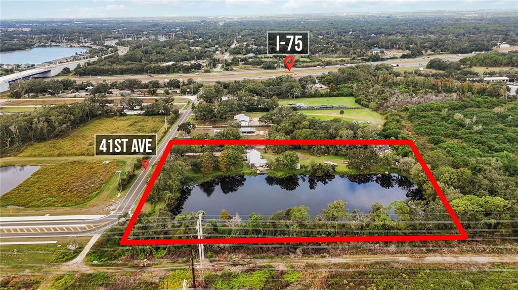 An aerial view shows a rectangular property with a pond, trees, and a house — 8011 41ST AVENUE E, BRADENTON, FL