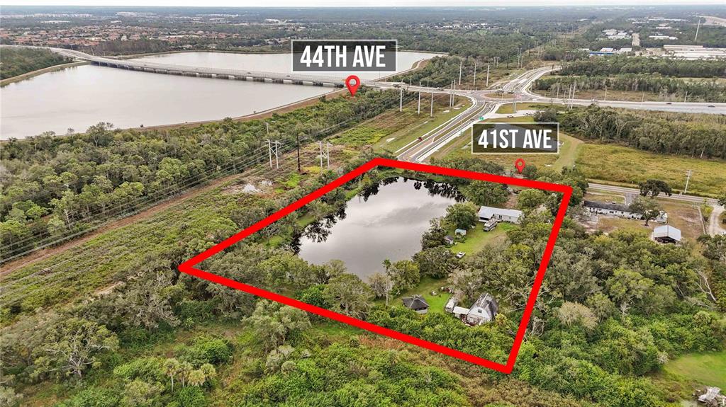 An aerial view shows a rectangular property containing a pond and several small buildings — 8011 41ST AVENUE E, BRADENTON, FL