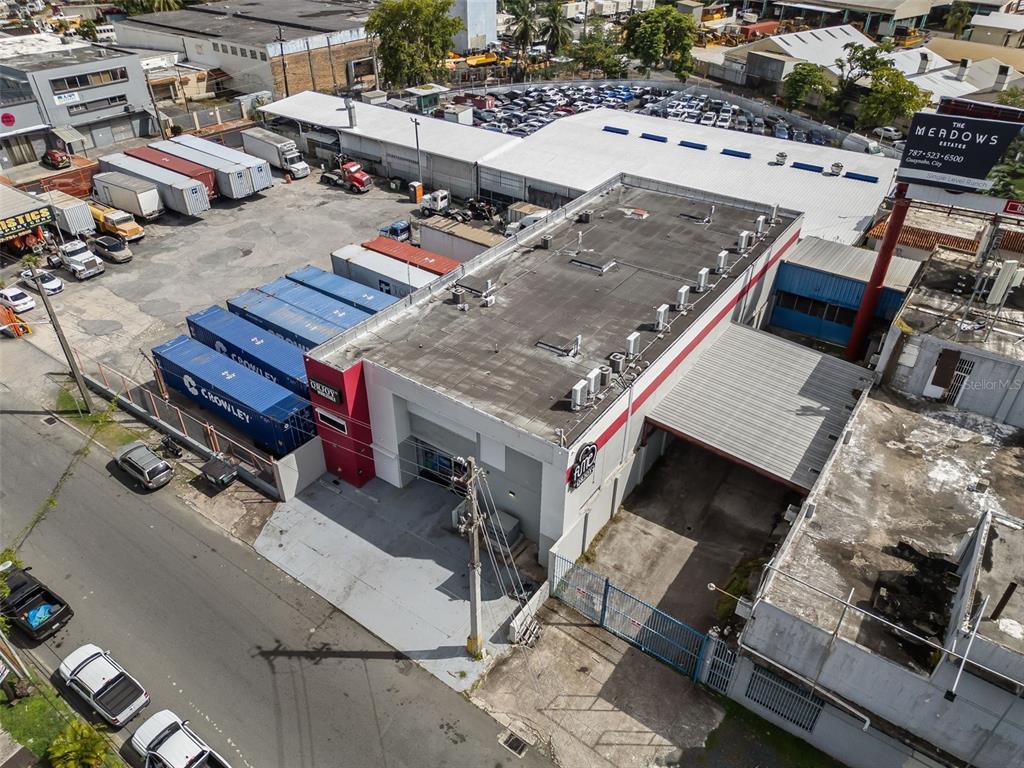 An aerial view shows a commercial building with shipping containers, a parking lot, and a billboard — 168-198 CALLE MONTERREY, SAN JUAN, PR