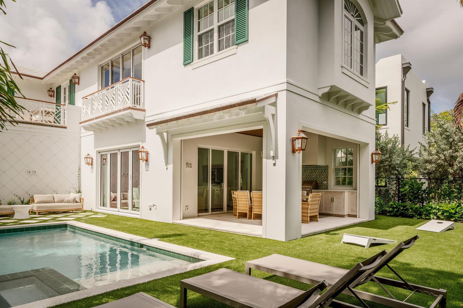A white two-story house features a swimming pool, covered patio, and green lawn — 309 Greymon Drive, West Palm Beach FL 33405, WEST PALM BEACH, FL