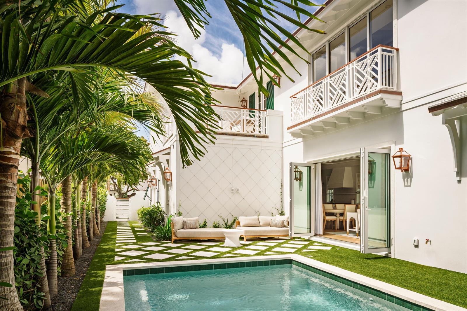 A white two-story house with a swimming pool, patio, and palm trees in the backyard — 309 Greymon Drive, West Palm Beach FL 33405, WEST PALM BEACH, FL