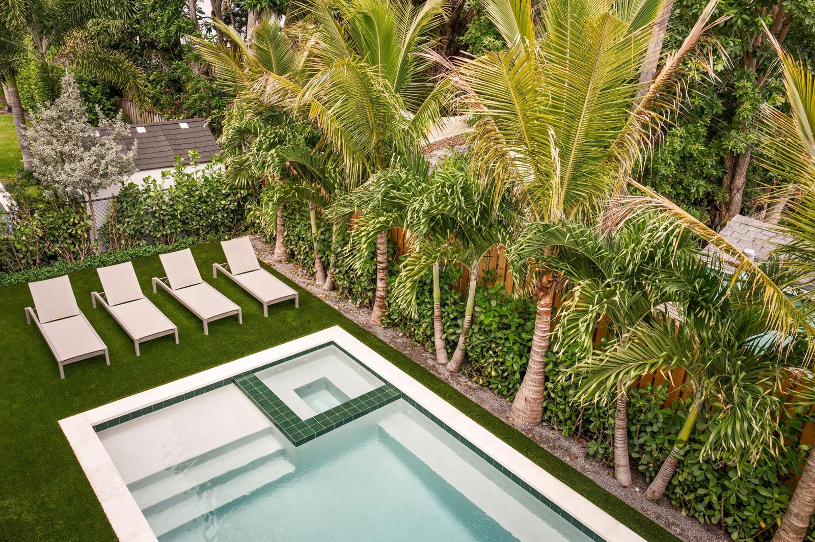 An aerial view of a swimming pool, hot tub, and four lounge chairs on grass — 309 Greymon Drive, West Palm Beach FL 33405, WEST PALM BEACH, FL