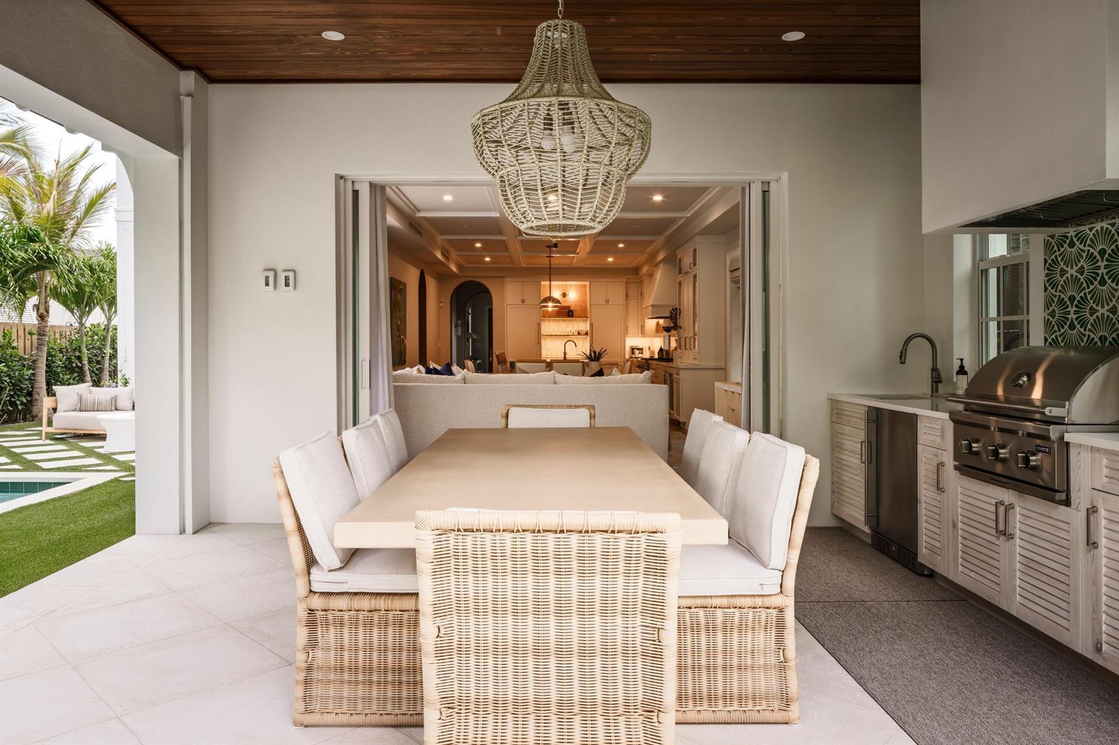 An outdoor dining area features a wicker-backed table set, a pendant light, and a grill — 309 Greymon Drive, West Palm Beach FL 33405, WEST PALM BEACH, FL