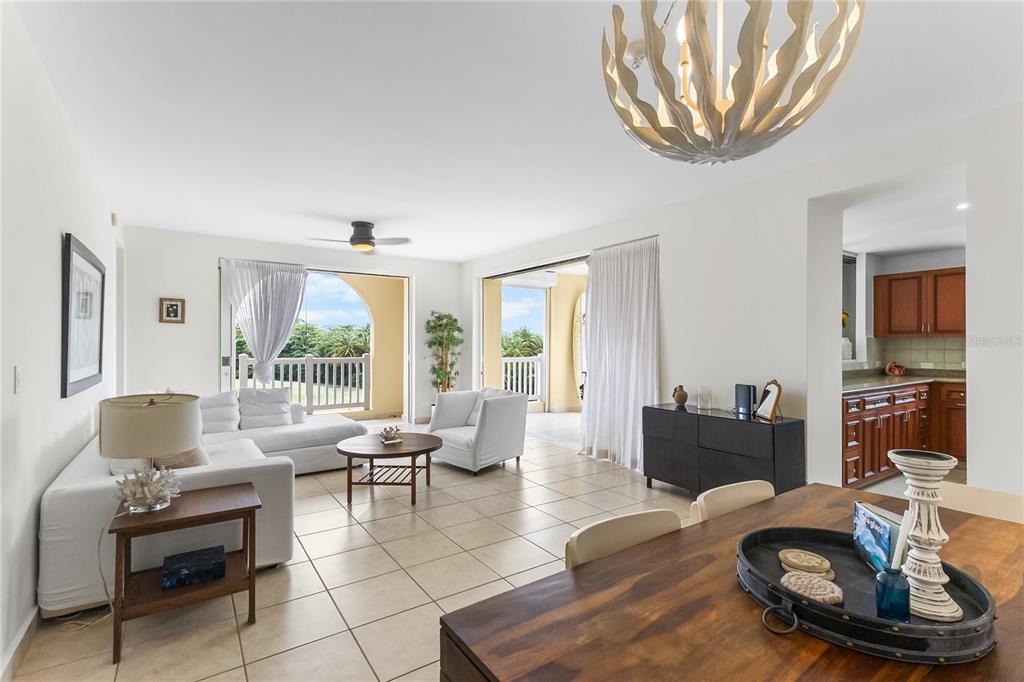 A bright living and dining area features white furniture, tile floors, and large sliding glass doors — 500 OCEAN DRIVE UNIT 535, HUMACAO, PR