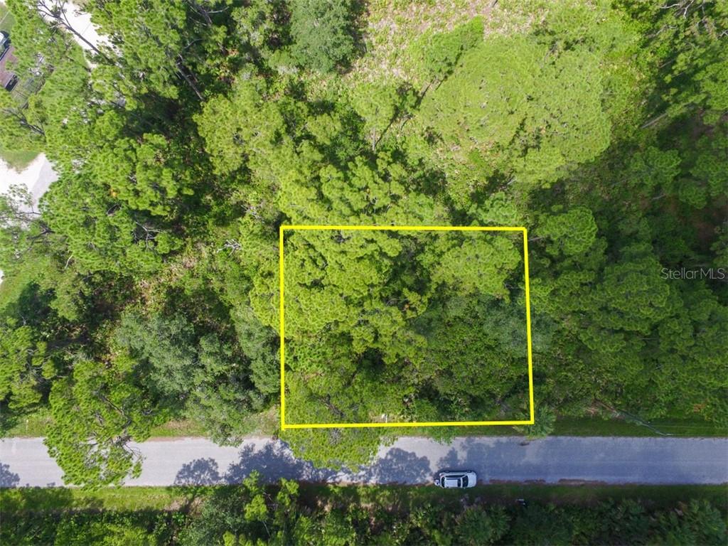 An aerial view shows a rectangular plot of land outlined in yellow beside a road — LOTS 15,16,17 TEGASTAS STREET, NORTH PORT, FL