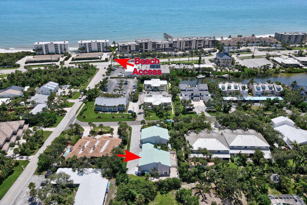 An aerial view shows a coastal neighborhood with a beach access path and residential buildings — VERO BEACH, FL