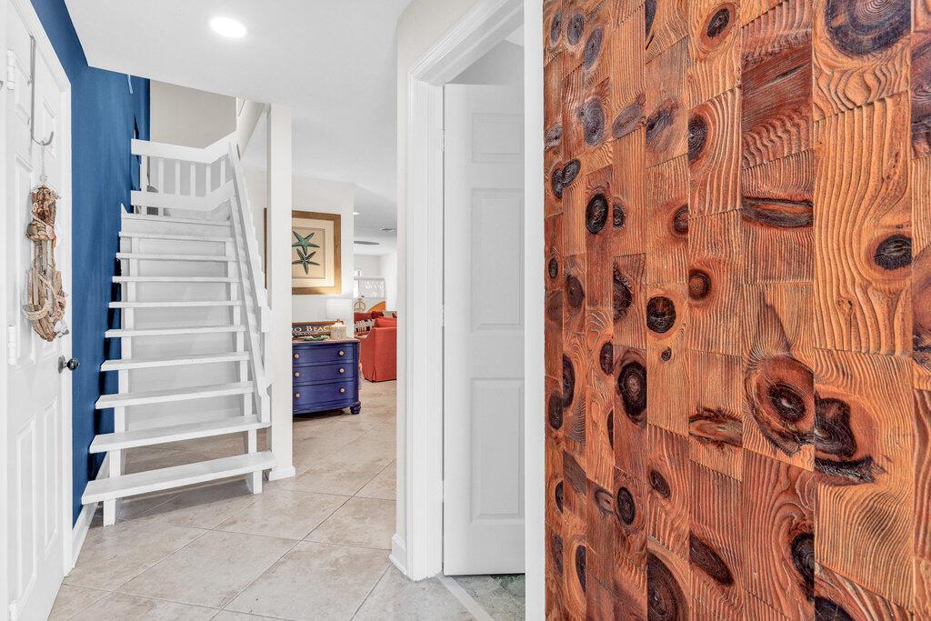 A hallway features a wooden accent wall, a white staircase, and a blue-painted wall — VERO BEACH, FL