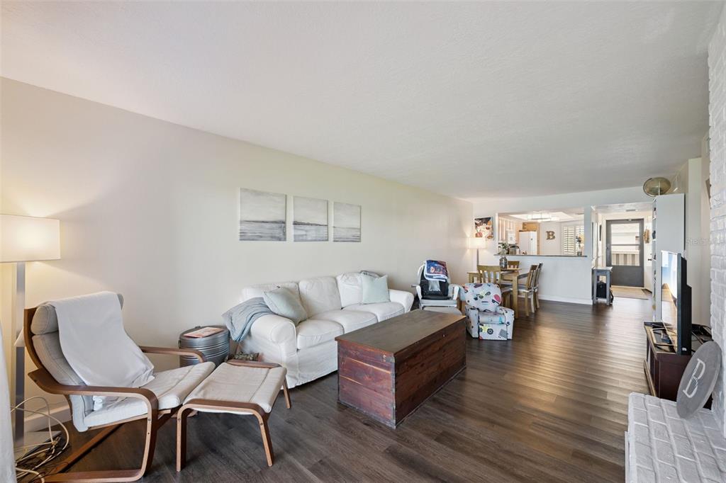 A living room features a white brick fireplace, dark wood flooring, and a television console — 4109 FAIRVIEW VISTA POINT UNIT 114, ORLANDO, FL