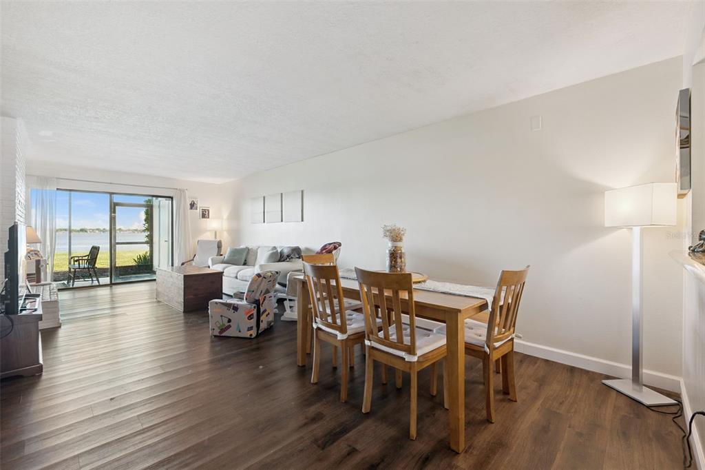 A living room with wood-look flooring, a white sofa, a wooden chest, and an armchair — 4109 FAIRVIEW VISTA POINT UNIT 114, ORLANDO, FL