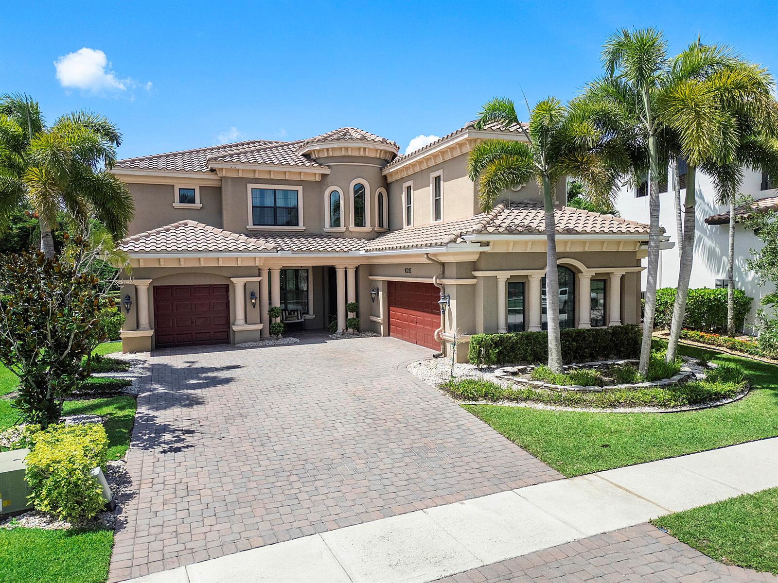 A two-story stucco house with a tile roof, three-car garage, and palm trees — 10282 Emerson Street, Parkland FL 33076, PARKLAND, FL