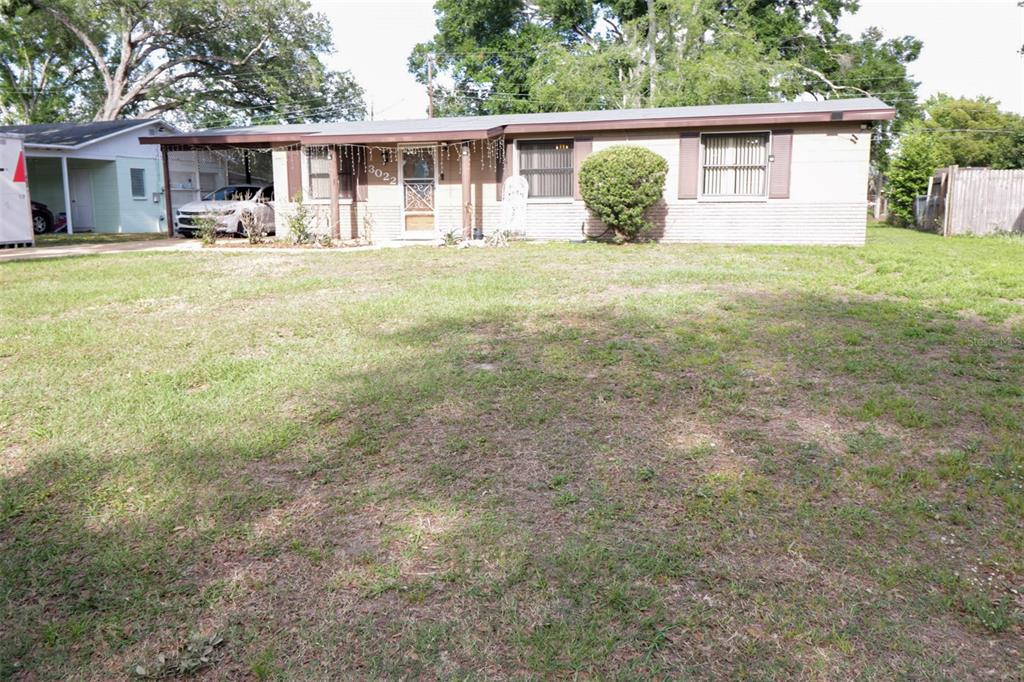 A single-story house with a carport, tan siding, and a large front lawn — 3022 VENICE WAY, LAKELAND, FL