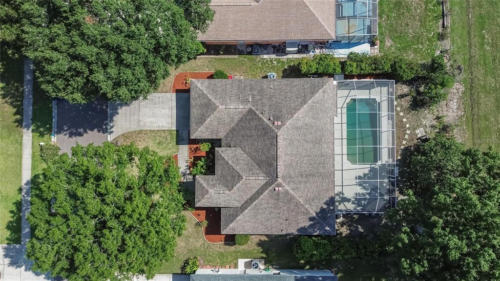 An aerial view shows a house with a shingled roof, pool cage, and surrounding trees — 3212 CONCORD WAY, PLANT CITY, FL