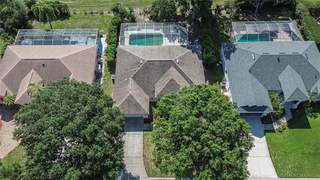 An aerial view shows three suburban houses with screened-in pools and large trees in front — 3212 CONCORD WAY, PLANT CITY, FL