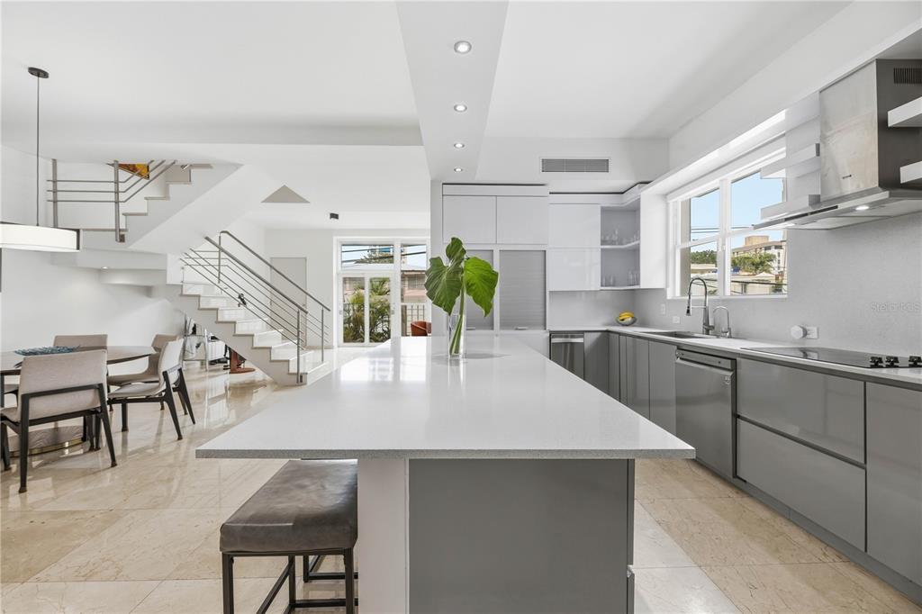A modern kitchen features a large white island, gray cabinetry, and a staircase nearby — 1362 MAGDALENA AVENUE UNIT Villa 109, SAN JUAN, PR