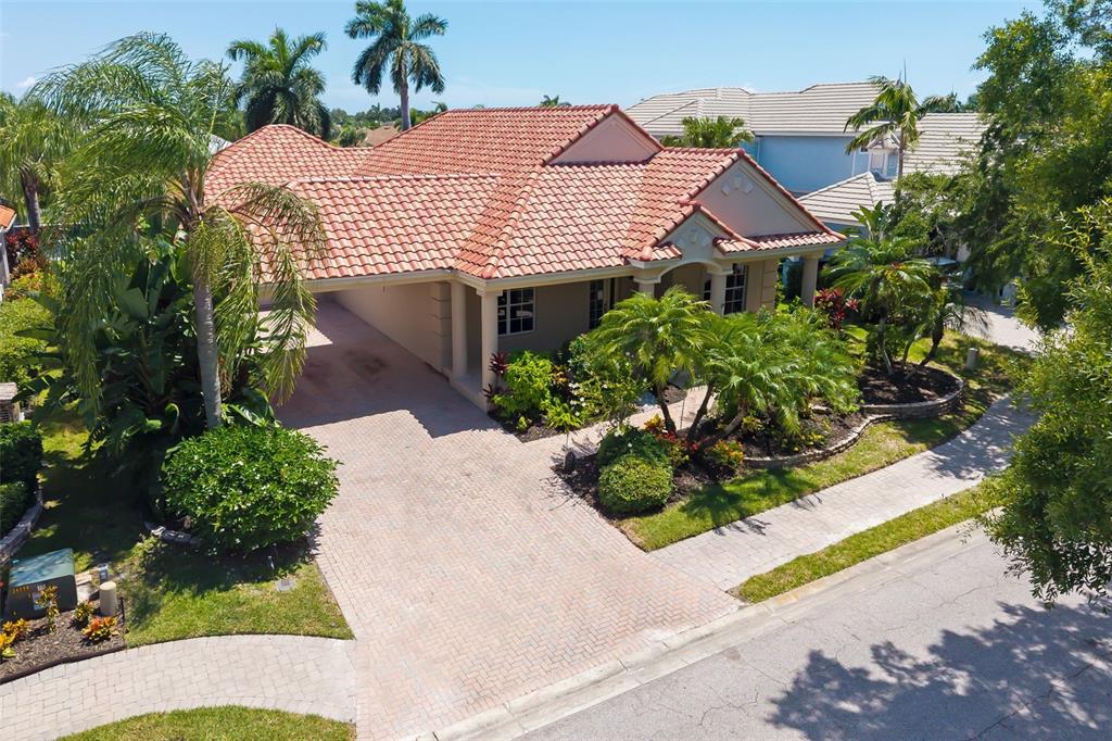An aerial view of a single-story house with a tile roof and a paved driveway — 4770 MAINSAIL DRIVE, BRADENTON, FL