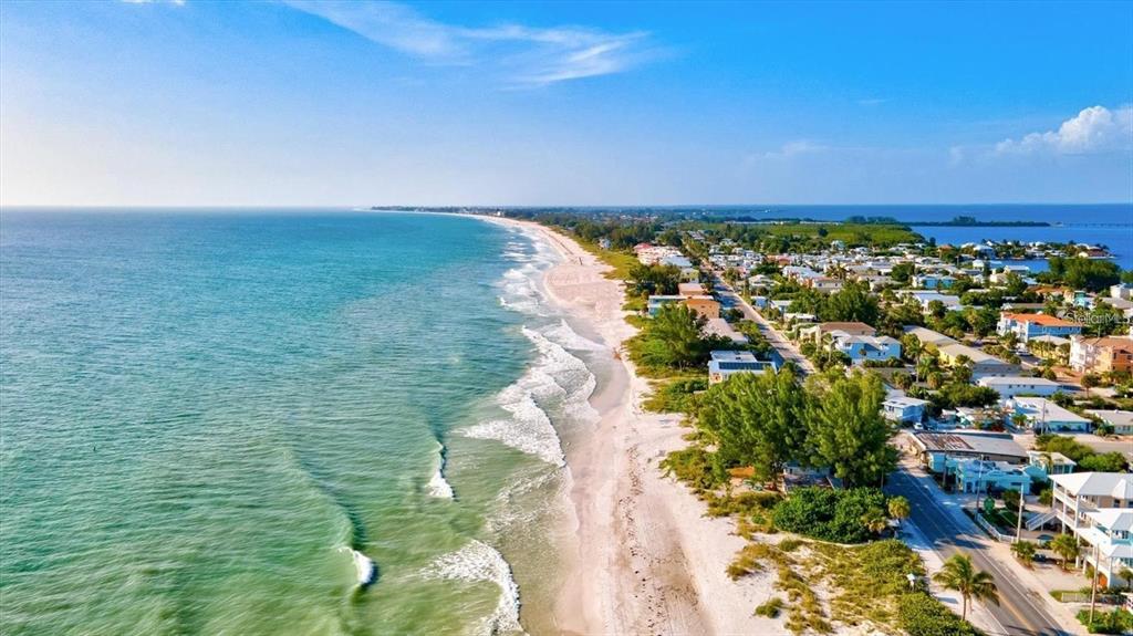 An aerial view of a sandy beach coastline with houses and a road nearby — 4770 MAINSAIL DRIVE, BRADENTON, FL