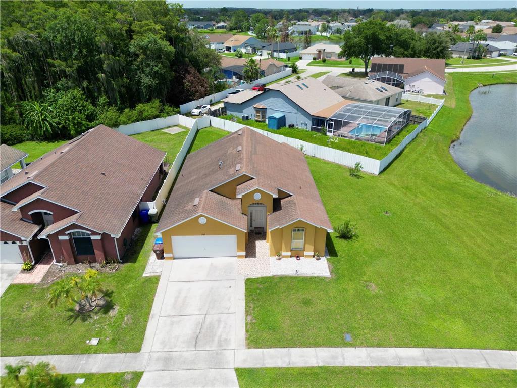 An aerial view shows a yellow single-story house with a garage and a large yard — 2169 REMINGTON POINTE BOULEVARD, KISSIMMEE, FL