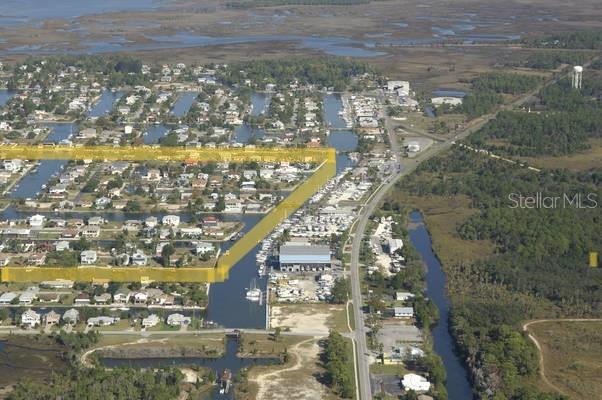 An aerial view shows a residential neighborhood with a canal and highlighted land parcels — 4011 CENTAVO COURT, HERNANDO BEACH, FL