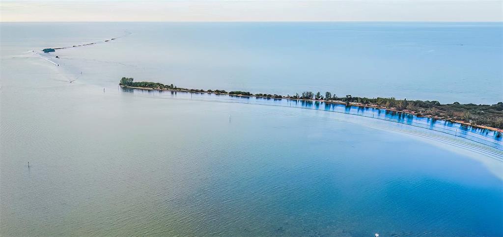 An aerial view shows a long, narrow barrier island surrounded by calm, blue coastal waters — 4011 CENTAVO COURT, HERNANDO BEACH, FL