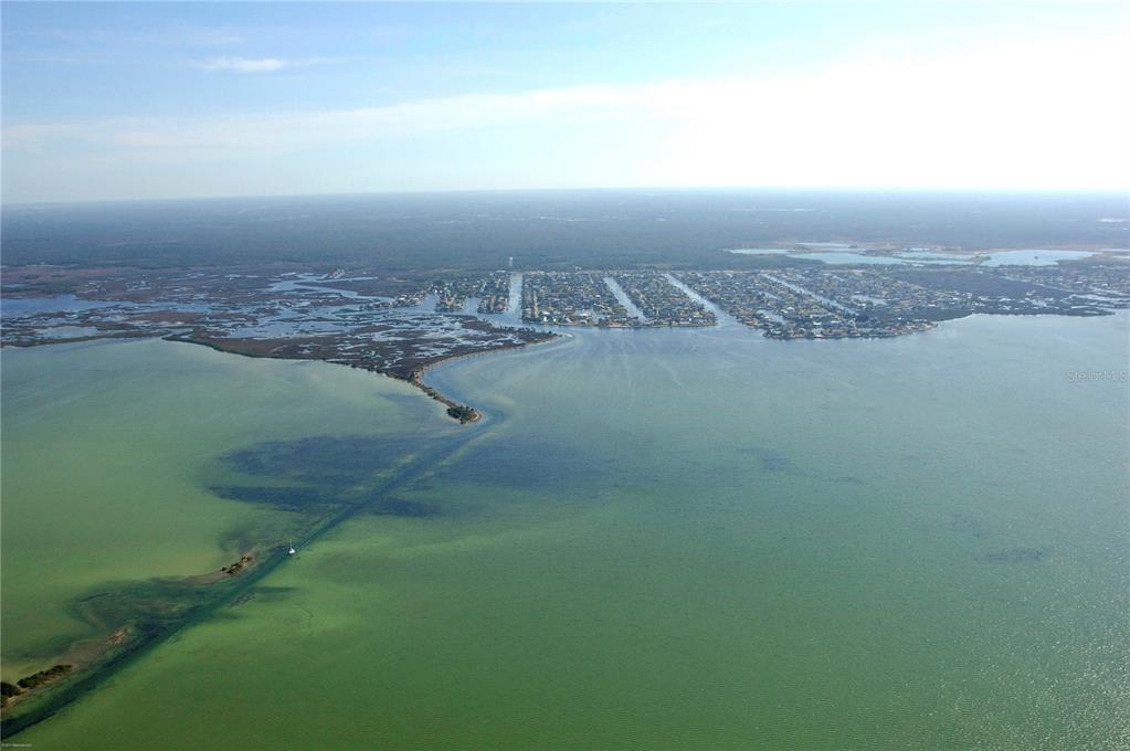 An aerial view shows a coastal residential community extending into a large body of water — 4011 CENTAVO COURT, HERNANDO BEACH, FL