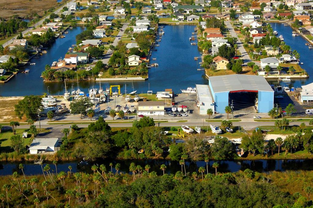 An aerial view of a waterfront marina with a large blue storage building and boats — 4011 CENTAVO COURT, HERNANDO BEACH, FL