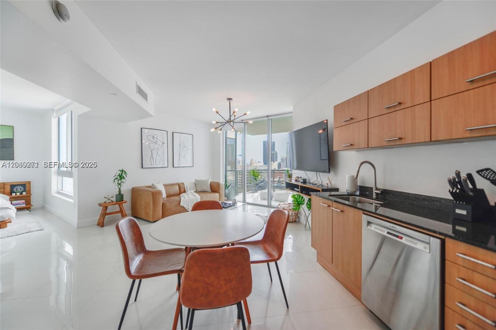 An open-concept living area features a kitchen with wood cabinets, a dining table, and balcony — 350 S Miami Ave # 1911, Miami FL 33130, MIAMI, FL