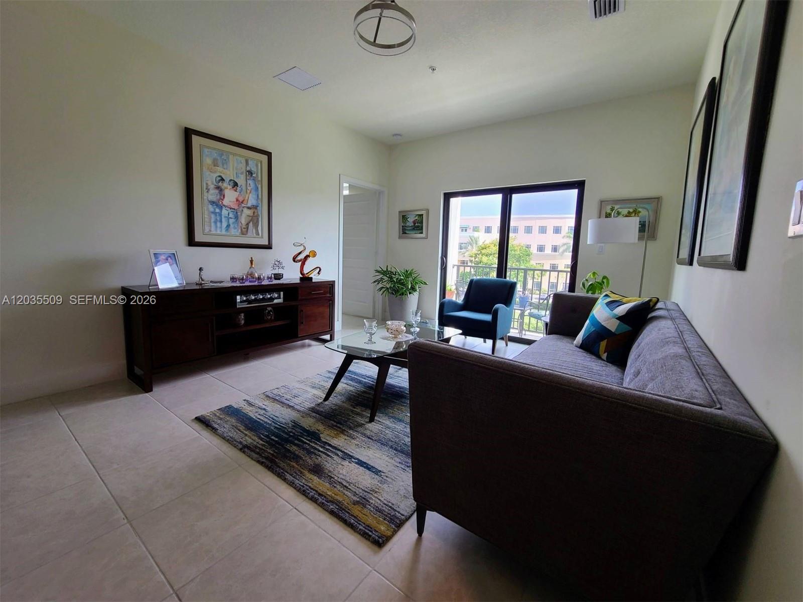 A living room features a grey sofa, a glass coffee table, and a dark wood console — 8301 NW 41st # 302, Doral FL 33166, DORAL, FL