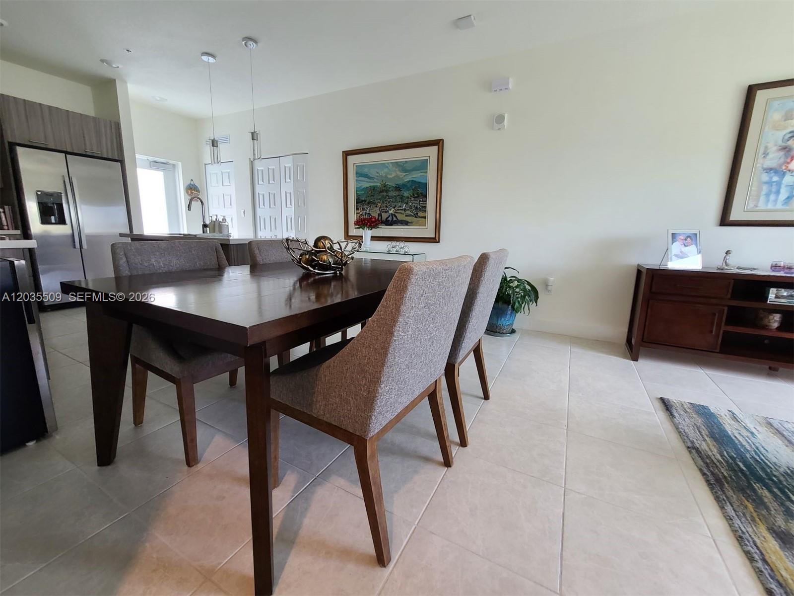 A dining room features a dark wood table, gray upholstered chairs, and tile flooring — 8301 NW 41st # 302, Doral FL 33166, DORAL, FL