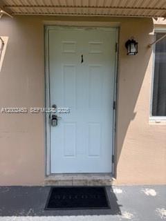 A bathroom features a white vanity, a toilet, and a shower-tub combination with patterned curtains — 50 W 11th St # 1, Hialeah FL 33010, HIALEAH, FL